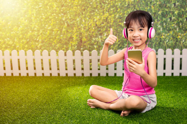 asiat chinoise peu jouer avec le téléphone mobile - garden fence audio photos et images de collection