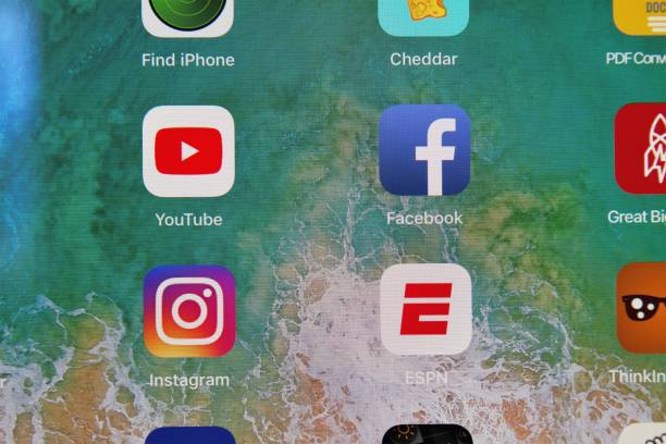 Various social media apps, including YouTube, Facebook, and Instagram, on an Apple iPad tablet screen. Also ESPN and multiple other partial app icons are visible.