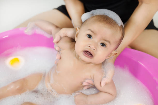 istock baby taking a bath in bathtub and playing with foam bubbles 1028005290