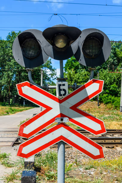 railroad crossing sign and semaphore in front of the railroad crossing - railroad crossing railway signal gate nobody imagens e fotografias de stock