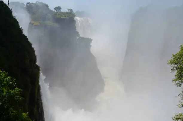 The Victoria falls shrouded by a mist from the raging waters.
