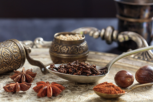 Black and red seasoning pepper with wood spoon and mill over white table in the kitchen at home.Image made in studio