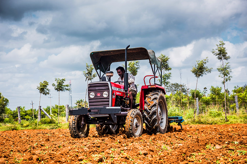Bangalore, Karnataka/India - August 21, 2018: Farmer Harrowing Agricultural Field By A Large Harrowing Machine