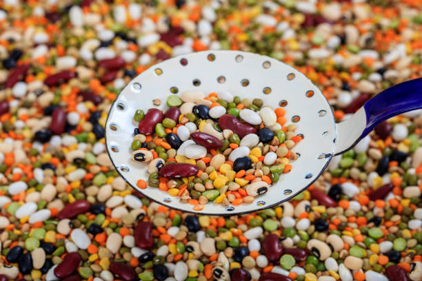 Mix organic nuts with soybean, red beans, green mung bean and black gram) in wooden bowl isolated on white background. Clipping path.