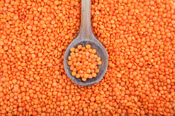 istock Wooden spoon on orange lentils background 1028044590