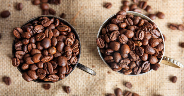 istock Coffee beans in old cups on a burlap 1028045092