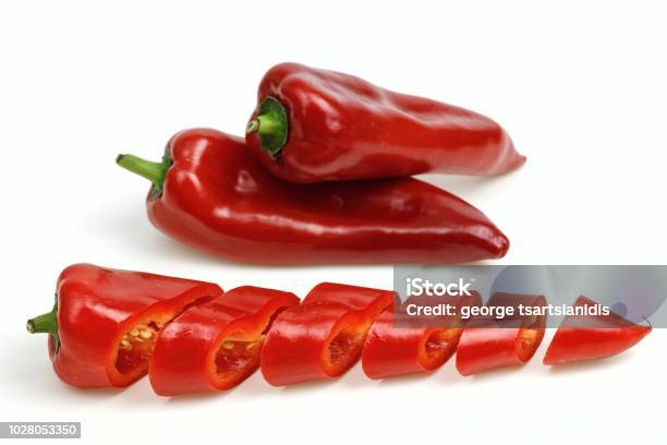Pointy Red Peppers And One Cut Into Pieces On White Background Stock Photo - Download Image Now