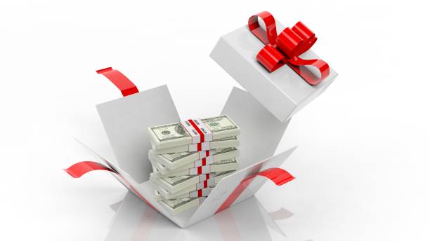 istock 100 dollar banknotes stacks in opened giftbox with red ribbon, isolated on white background 1028053890