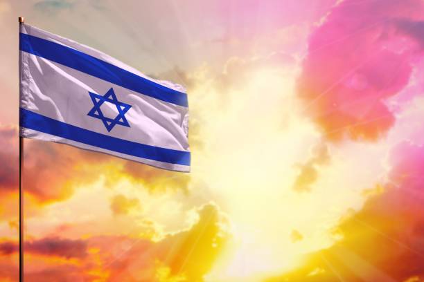 istock Fluttering Israel flag in top left corner mockup with the space for your text on beautiful colorful sunset or sunrise background. 1028067252