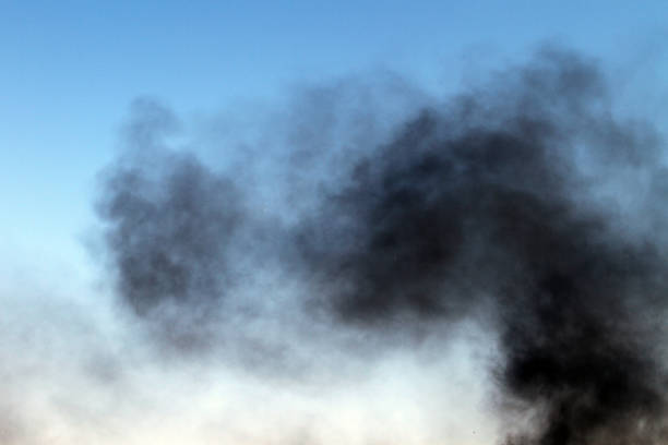 istock heavy smoke pillar on the blue sky background. 1028067506
