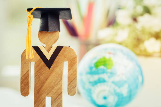 istock Australia Education knowledge learning study abroad international Ideas. People Sign wood with Graduation celebrating cap on open textbook with model global map, alternative studying world wide 1028078762