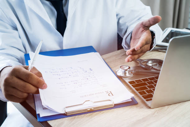 mão de médico de medicina explicando para o paciente no quarto, de consultoria, trabalhando no computador portátil na mesa na clínica, um estetoscópio de foco na tabela de primeiro plano no hostpital. conceito de saúde e médico. - hostpital - fotografias e filmes do acervo