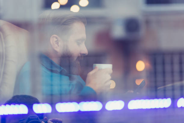 istock Young, redhead businessman, on coffee break, using mobile phone. He is sitting in cafe, drinking coffee 1028084918