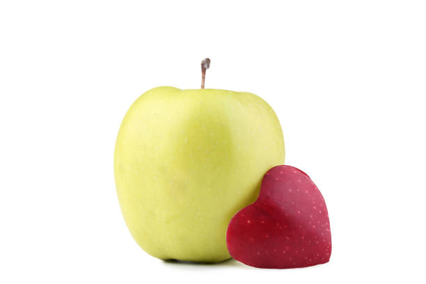 istock Green apple with cutout heart shape on white background 1028091786