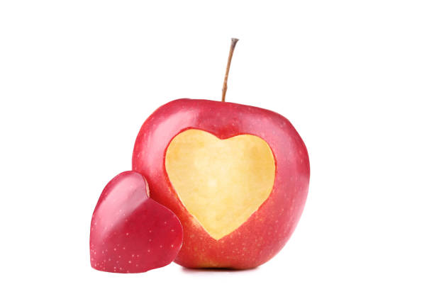 istock Red apple with cutout heart shape on white background 1028092154