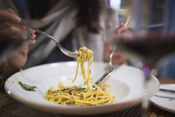 istock Young women eating pasta in restaurant 1028093022