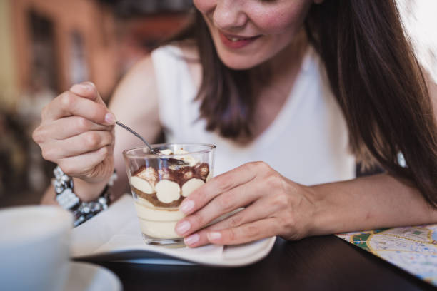 mulheres jovens descobrindo a itália. as mulheres jovens a gostar de café e tiramisu bolo em verona-itália - starbucks women walking restaurant - fotografias e filmes do acervo