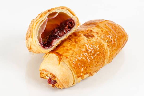 istock Tasty puff pastry dessert cut in half . Delicious pastries with fruit jam on light background. berry, strawberries or raspberries 1028107514