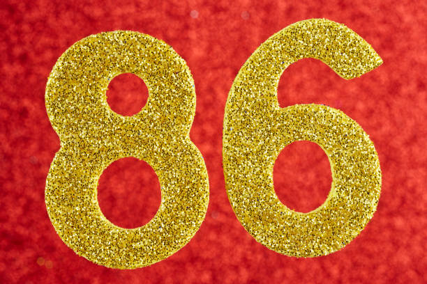 istock Number eighty-six gold color over a red background. Anniversary. 1028107814