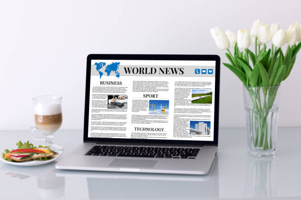 istock Computer with app world news on table in cafe 1028112116