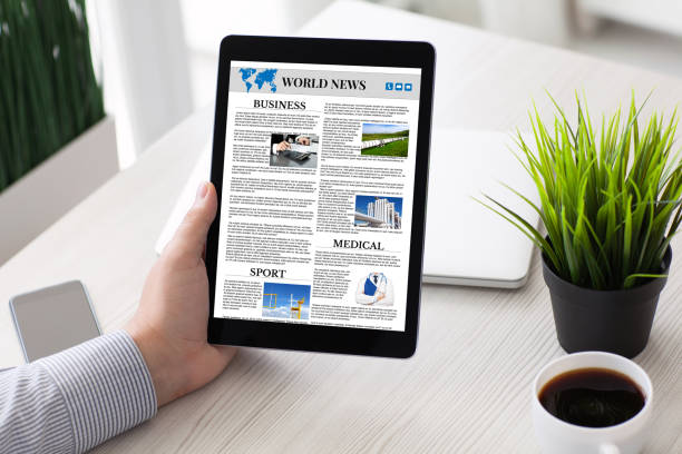 istock man hand holding computer tablet with app world news screen 1028112226