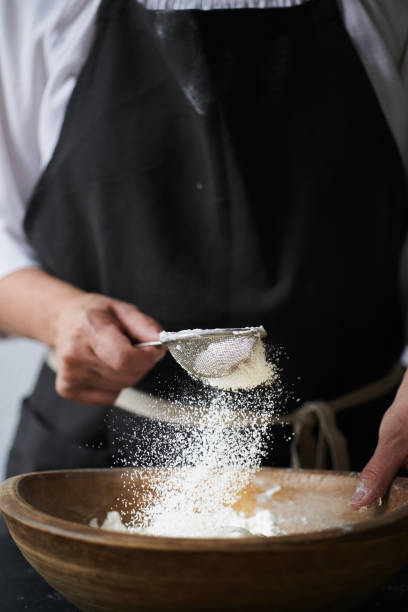 istock Female hands sifting flour to bowl. 1028112510