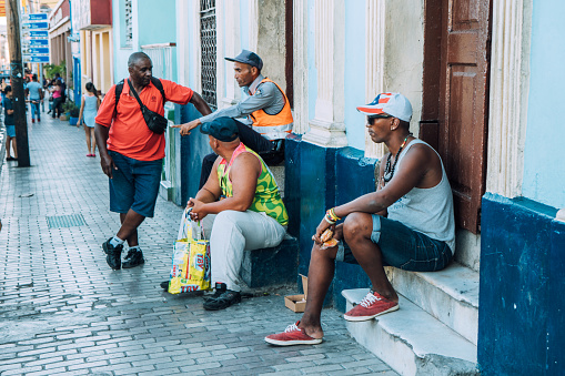 Santiago de Cuba, Cuba on February 14, 2017: People sitting, standing and talking in the streets of Santiago de Cuba.
