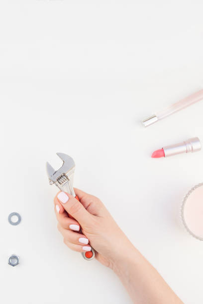 istock Female hand holding spanner on white background 1028122418
