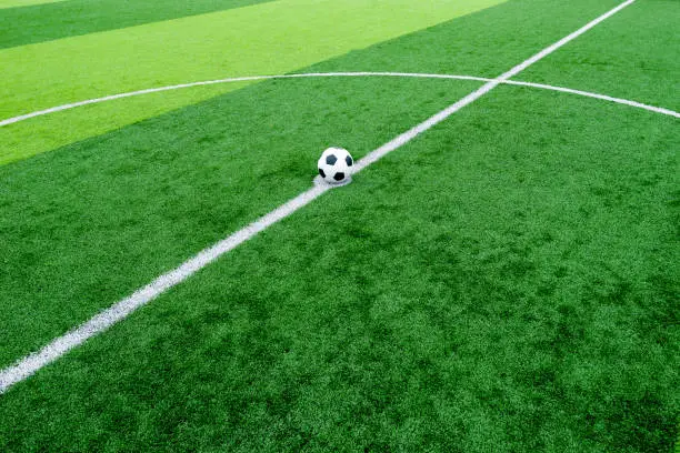 Photo of soccer field grass with ball at kick off point