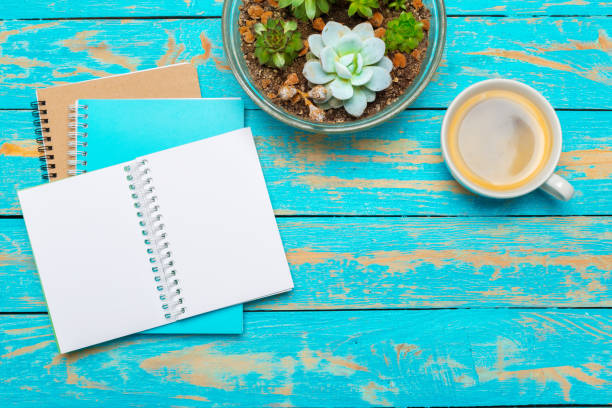 istock Cup of coffee with notebook on wooden desk 1028124392