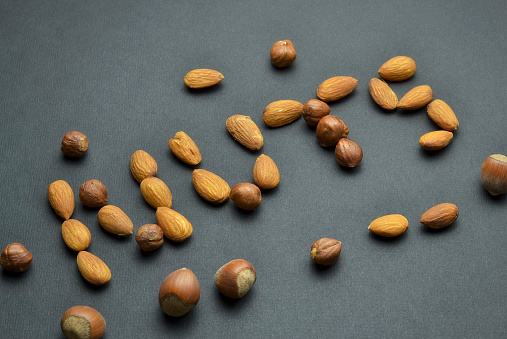 Nuts loose on a black background. Walnuts, almonds and hazelnuts closeup in focus.