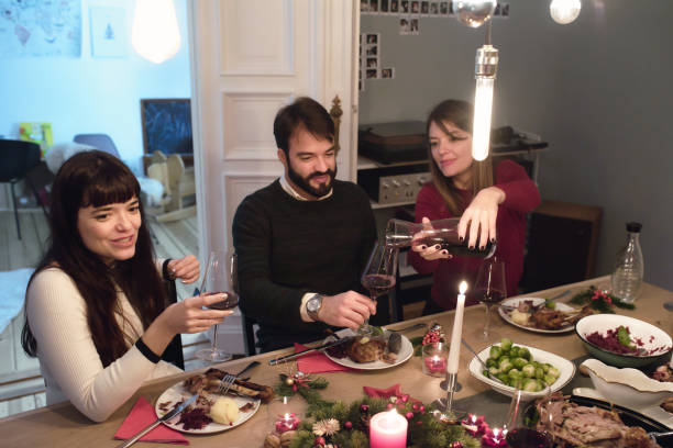 istock friends drinking wine together at christmas table 1028135614