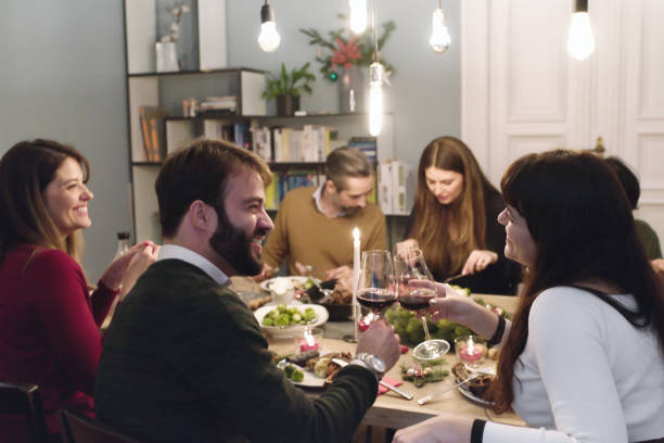 istock friends drinking wine together at christmas table 1028135700