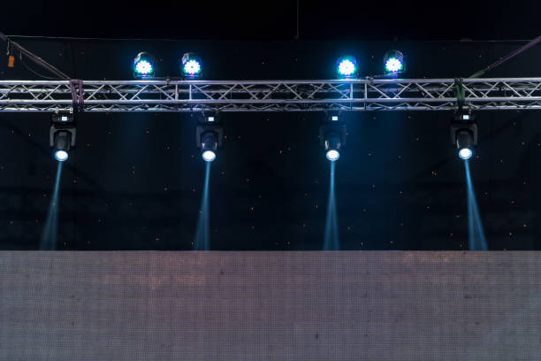 istock Luminous rays from concert lighting against a dark background over the projector screen, musical instrument concept 1028135756