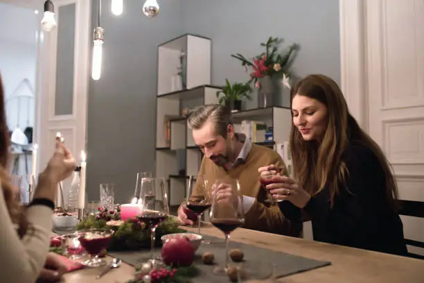 young people eating dessert together at christmas table