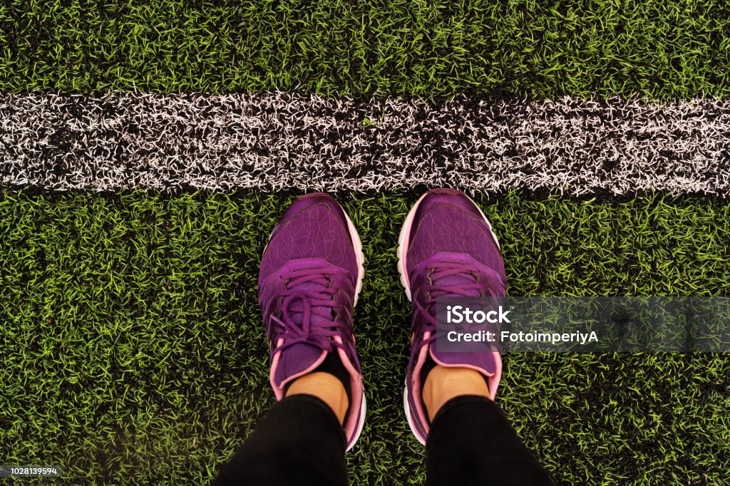 hình ảnh đôi chân từ trên cao trong đôi giày thể thao màu hoa cà trên sân bóng đá - Trả phí Bản quyền Một lần Bàn chân - Bộ phận cơ thể Bức ảnh sẵn có