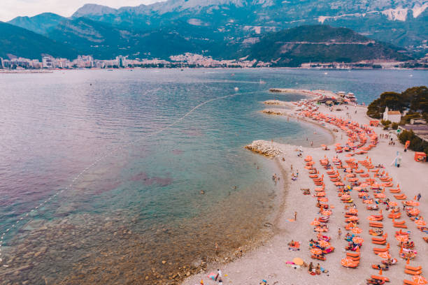 BUDVA, MONTENEGRO - JULY 21, 2018: people resting at hawaii beach in montenegro. budva city on background