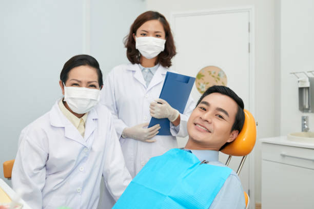 istock Smiling patient and doctors in dental office 1028144522