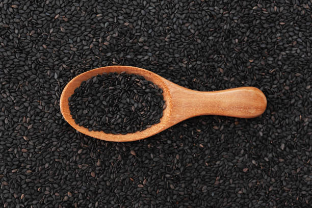 istock Black sesame seeds on wooden spoon background texture pattern 1028148352