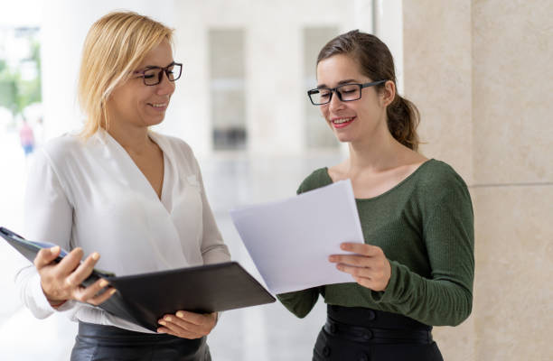 istock Smiling young manager giving paper report 1028150942
