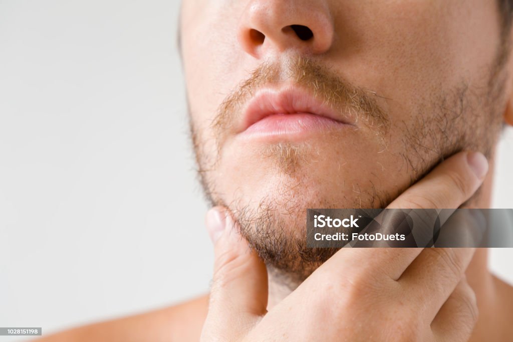 Man touching his short beard. Isolated on gray background. Men's issues. Face close up. Adult Stock Photo