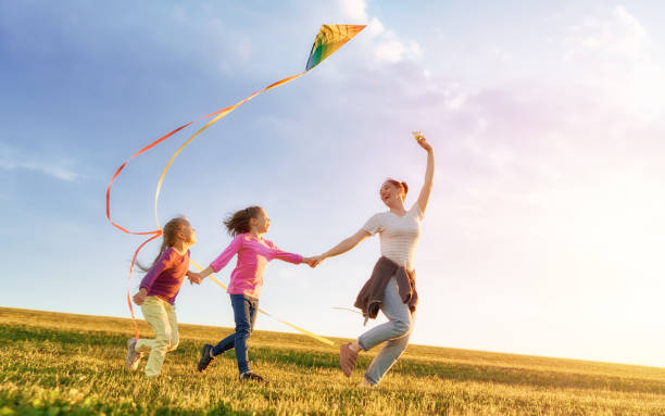 istock mother and two daughters are playing on meadow 1028154880
