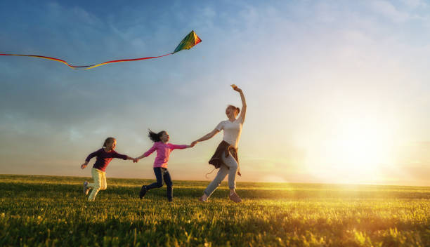 istock mother and two daughters are playing on meadow 1028154982