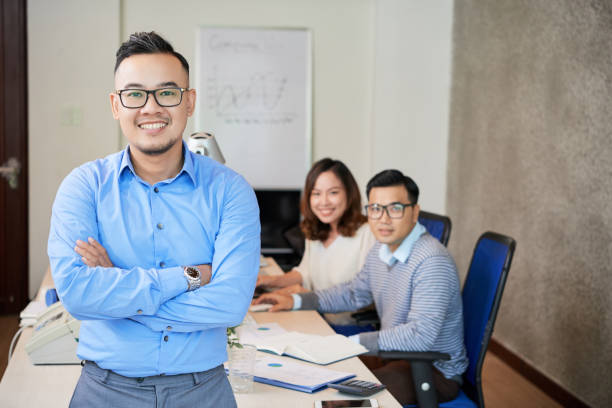 istock Smiling ethnic man in office with colleagues 1028156922