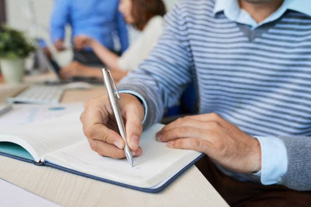 istock Crop casual man writing in notepad 1028156938