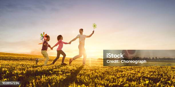 Photo libre de droit de Mère Et Ses Deux Filles Jouent Sur Prairie banque d'images et plus d'images libres de droit de Famille - Famille, Bonheur, Enfant