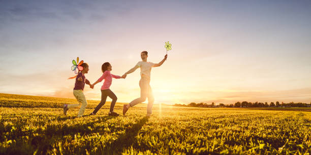 matka i dwie córki bawią się na łące - outdoors playing family spring zdjęcia i obrazy z banku zdjęć