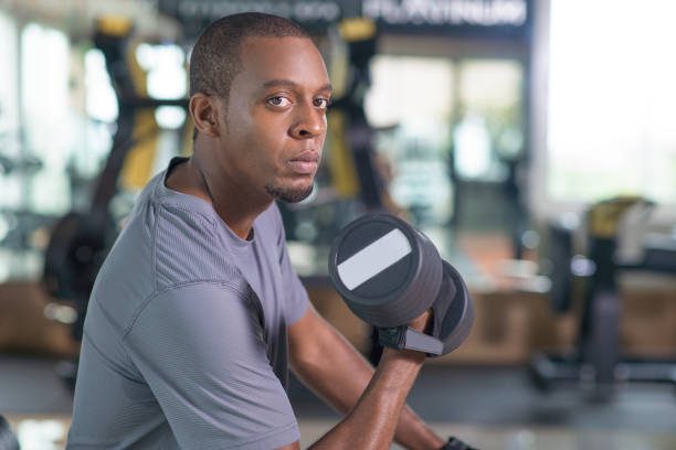 istock Black man training with dumbbell and looking at camera 1028159416