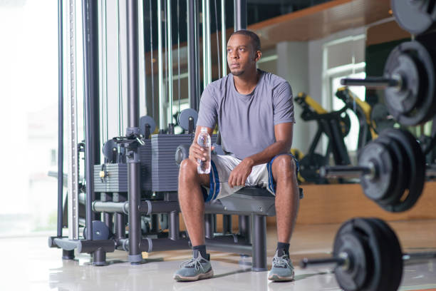 istock Pensive man sitting in gym, holding water bottle 1028159552