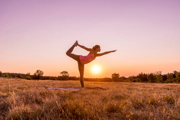 young beautiful woman practicing yoga outdoor in nature during sunset - shiva posture imagens e fotografias de stock